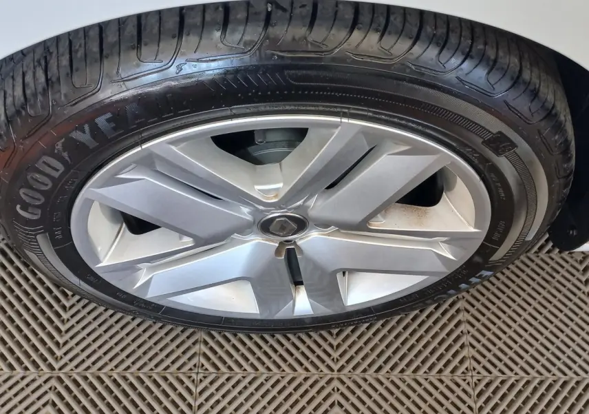 Gros plan sur la roue avant droite blanche d'une Renault Clio Business SCe 65 avec jante alliage et pneu Goodyear.