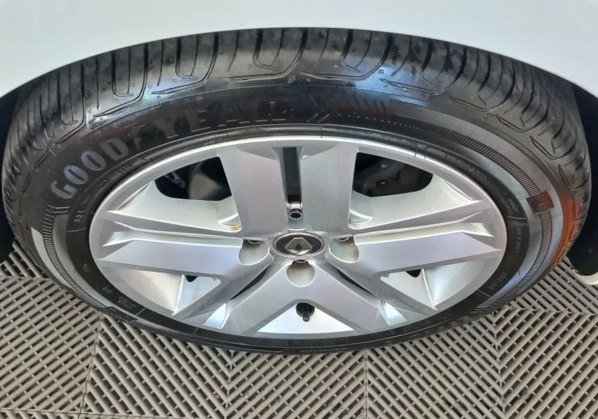 Gros plan sur la roue avant droite d'une Renault Clio Business blanche, jante alliage et pneu Goodyear visibles.