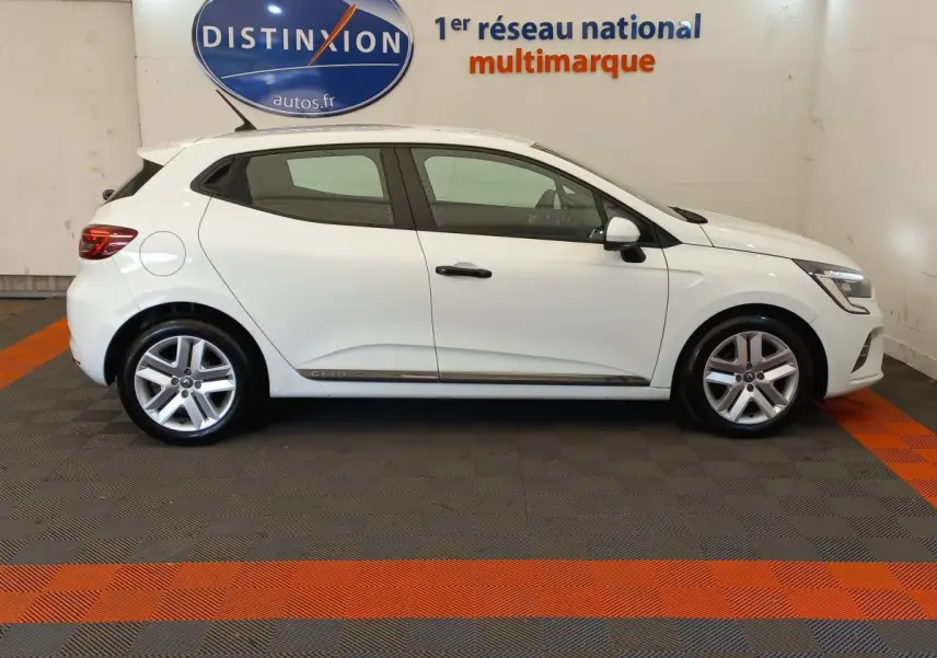 Profil côté gauche d'une Renault Clio Business blanche 2021, avec jantes alliage et poignées noires contrastantes.