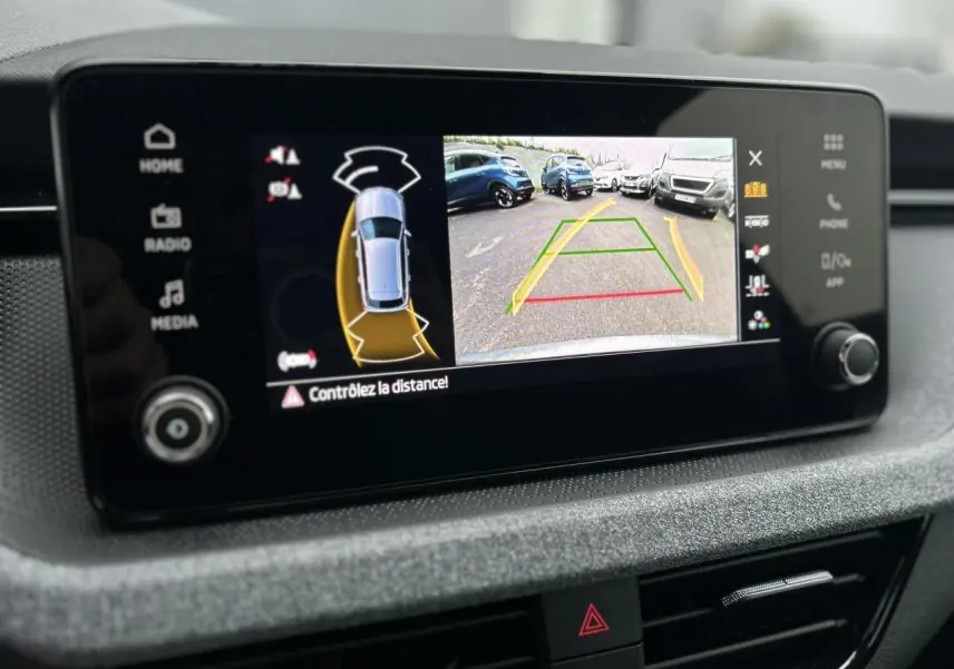 Écran central du Skoda Kamiq gris graphite montrant la caméra de recul avec aides au stationnement activées.