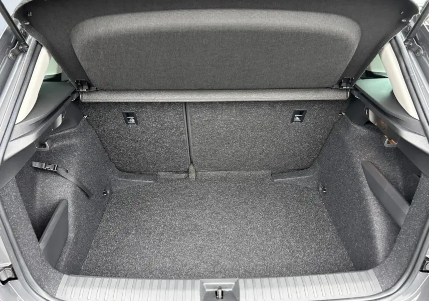 Coffre ouvert vu de l'arrière d'un Skoda Kamiq gris graphite, espace de chargement propre et vide.