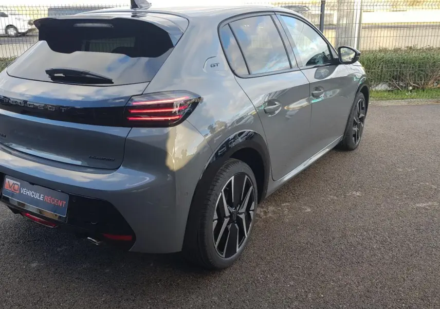 Vue 3/4 arrière droite d’une Peugeot 208 Hybrid 110 gris avec jantes alliage 17 pouces et feux LED distinctifs.