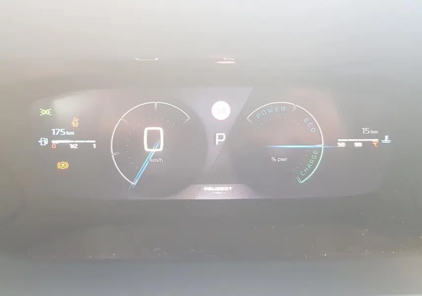 Tableau de bord numérique de la Peugeot 208 Hybrid 110 GT affichant la vitesse, autonomie et indicateurs d'énergie.