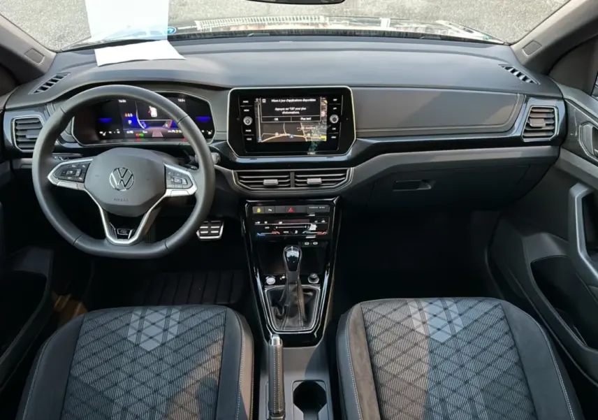 Vue intérieure du tableau de bord et console centrale du Volkswagen T-Cross gris cendré avec volant multifonctions et écran tactile.