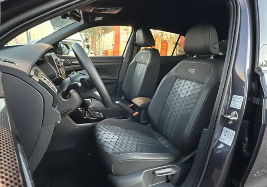 Intérieur du Volkswagen T-Cross gris cendré, vue côté gauche sur les sièges avant R-Line en tissu avec surpiqûres grises.