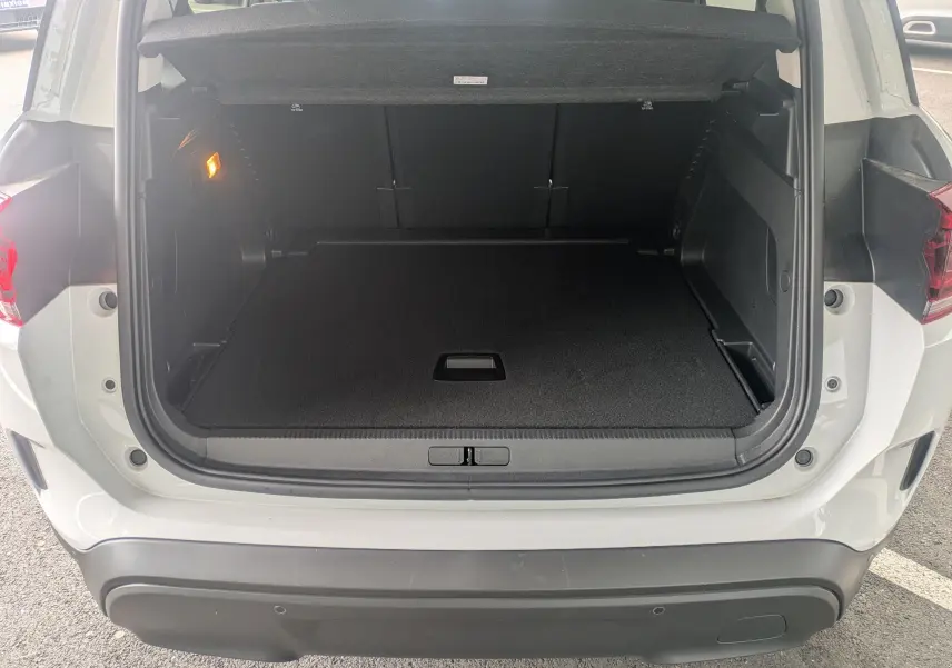Coffre ouvert vu de l'arrière d'un Citroën C5 Aircross blanc Okenite, montrant l'espace de chargement vide et la plage arrière.