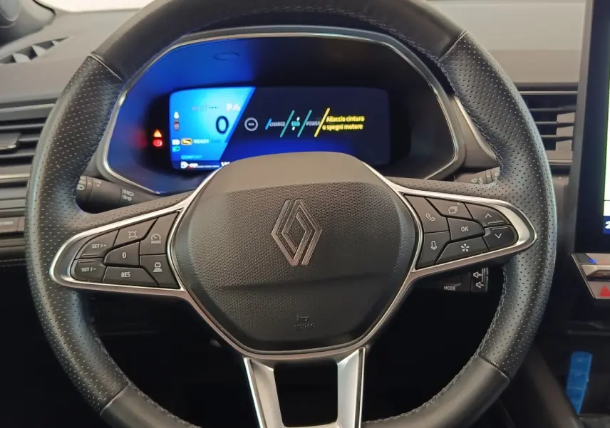 Vue rapprochée du volant cuir noir perforé de la Renault SYMBIOZ avec tableau de bord numérique lumineux en arrière-plan.