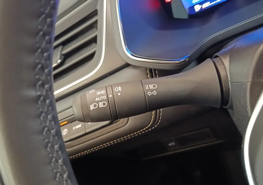 Gros plan sur la commande des phares et clignotants côté gauche du volant du Renault Symbioz noir, intérieur moderne.