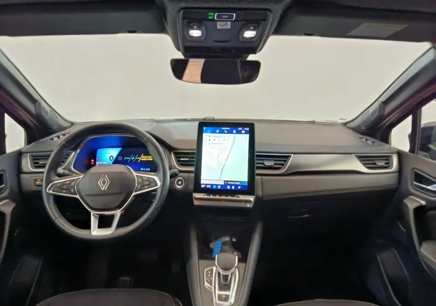 Vue intérieure avant du tableau de bord noir du Renault SYMBIOZ avec écran tactile vertical et volant multifonctions.
