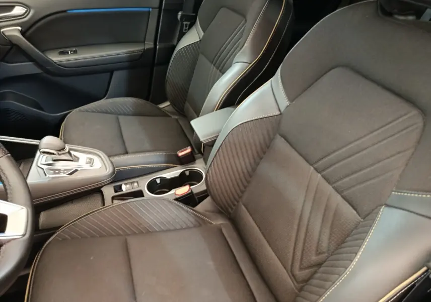Vue intérieure rapprochée des sièges avant noirs et console centrale avec levier de vitesse de la Renault SYMBIOZ Iconic E-Tech.