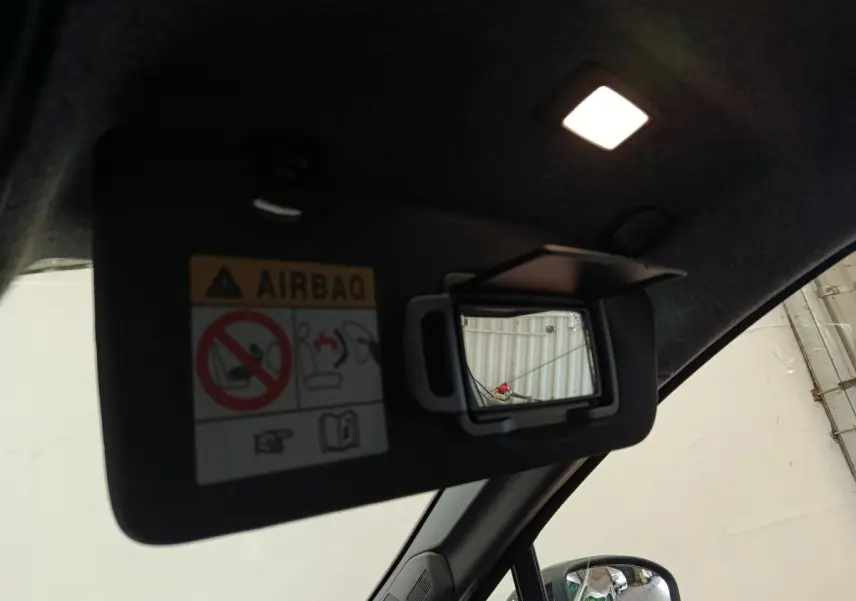 Détail du pare-soleil côté conducteur avec miroir de courtoisie ouvert dans un Renault Symbioz noir, vue intérieure.