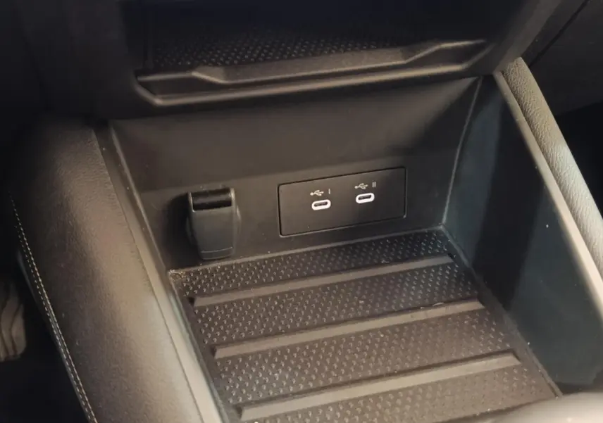 Vue rapprochée de la console centrale noire du Renault Symbioz avec prises USB-C et prise 12V visible.