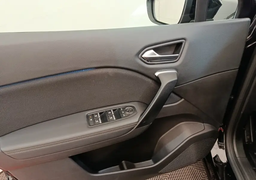 Vue intérieure du panneau de porte avant gauche noir du Renault Symbioz avec commandes électriques des vitres et rétroviseurs.