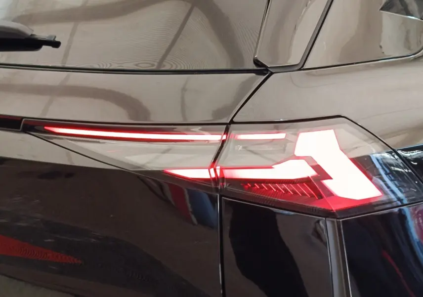 Feu arrière droit allumé du Renault Symbioz noir, vue rapprochée sur la ligne lumineuse fine et angulaire.