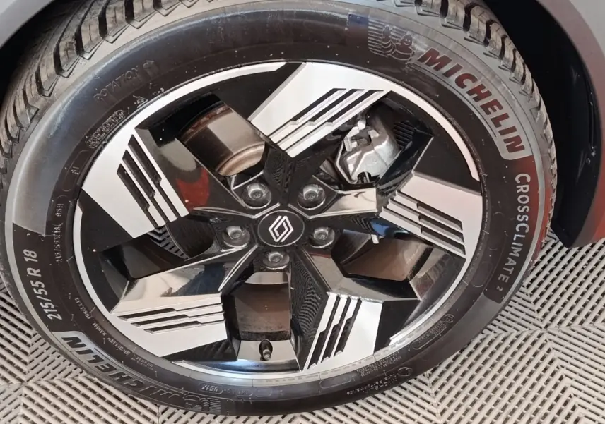 Gros plan sur la roue avant droite du Renault Symbioz noir, jante alliage bicolore au design moderne.
