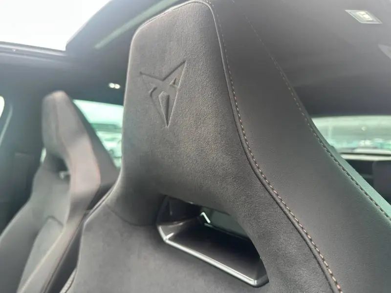 Gros plan sur l’appui-tête en alcantara noir avec logo Cupra embossé, sièges sport avant du Formentor.