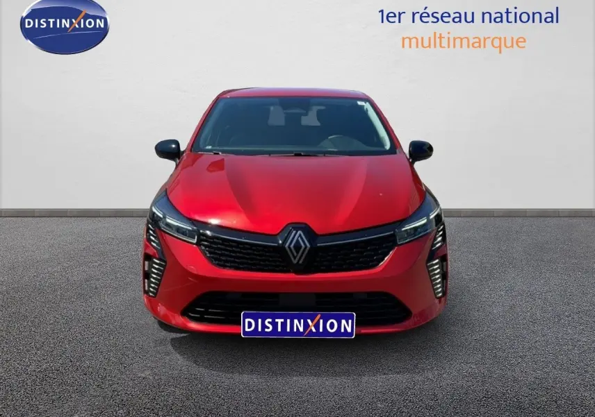 Vue frontale d'une Renault Clio 2025 rouge flamme métal avec calandre noire et feux LED verticaux allumés.