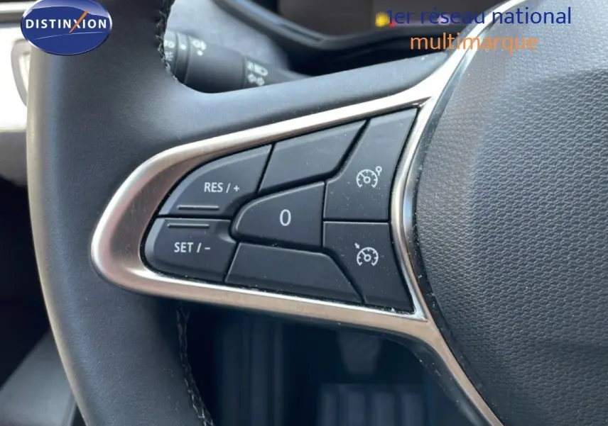 Gros plan sur les commandes de régulateur de vitesse au volant noir de la Renault Clio V BluedCi 2025.