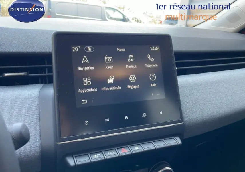 Vue intérieure du tableau de bord de la Renault Clio rouge flamme, écran tactile central avec commandes climatisation en dessous.