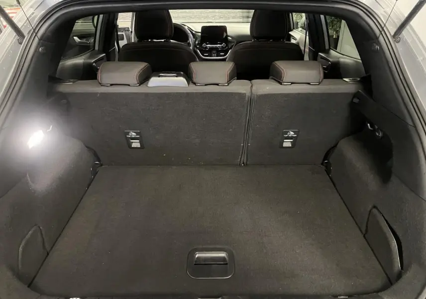 Coffre spacieux vu de l'arrière ouvert d'un Ford Puma gris avec banquette arrière noire et appuie-têtes visibles.