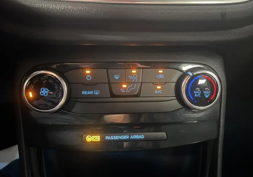 Panneau de commande de climatisation avec voyants allumés dans l'habitacle d'une Ford Puma gris 2021.