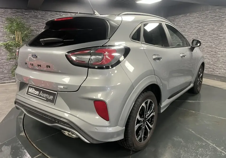 Vue 3/4 arrière droite du Ford Puma gris métallisé avec barres de toit noires et jantes alliage 17 pouces.