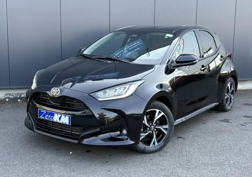 Toyota Yaris Hybride noire vue en 3/4 avant droit, avec jantes alliage et calandre noire brillante.
