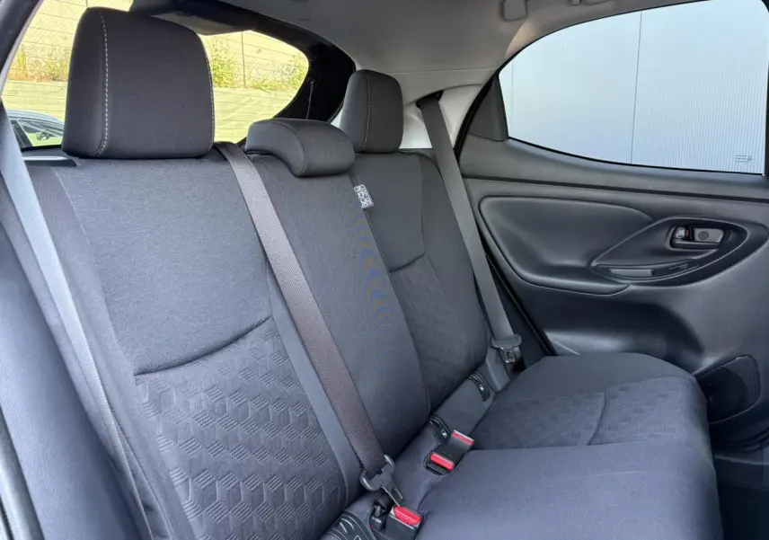 Vue latérale droite de la banquette arrière noire avec ceintures et appuie-tête dans une Toyota Yaris Hybride 2025.
