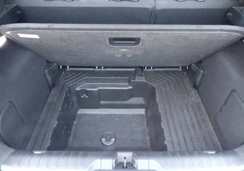 Coffre ouvert vu de dessus du Ford Puma blanc 2020, montrant le compartiment de rangement sous plancher.