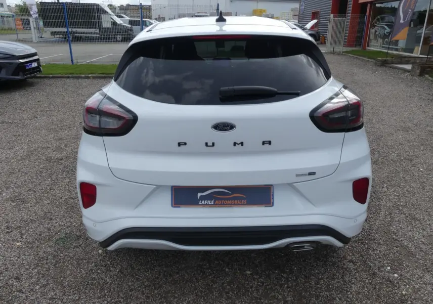 Vue arrière d'une Ford Puma blanche ST Line avec vitres arrière surteintées et sortie d'échappement chromée visible.