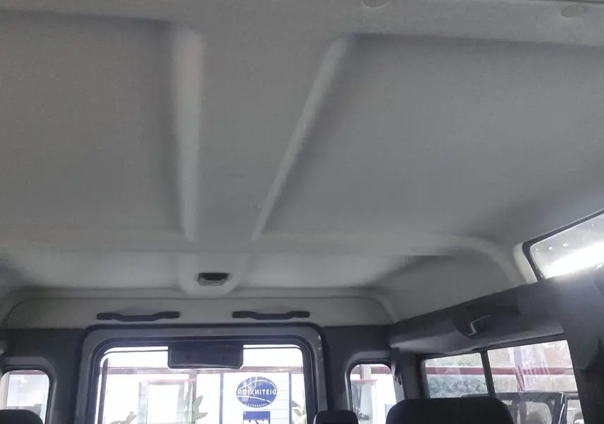 Intérieur du toit et des fenêtres arrière d'un Land Rover Defender 110 II Station Wagon gris, vue depuis l'arrière vers l'avant.