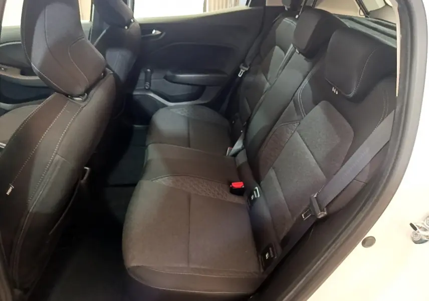 Vue intérieure sur la banquette arrière noire de la Renault Clio Business blanche, avec ceinture de sécurité visible côté droit.