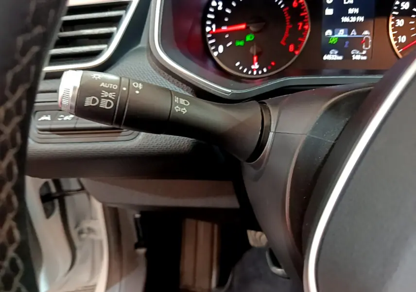 Gros plan sur la manette des feux et clignotants du tableau de bord d'une Renault Clio blanche 2021.