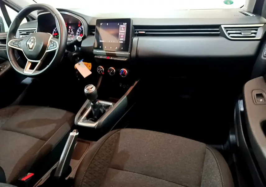 Intérieur de Renault Clio Business 2021, vue côté conducteur, volant cuir, écran tactile central et boîte manuelle visible.