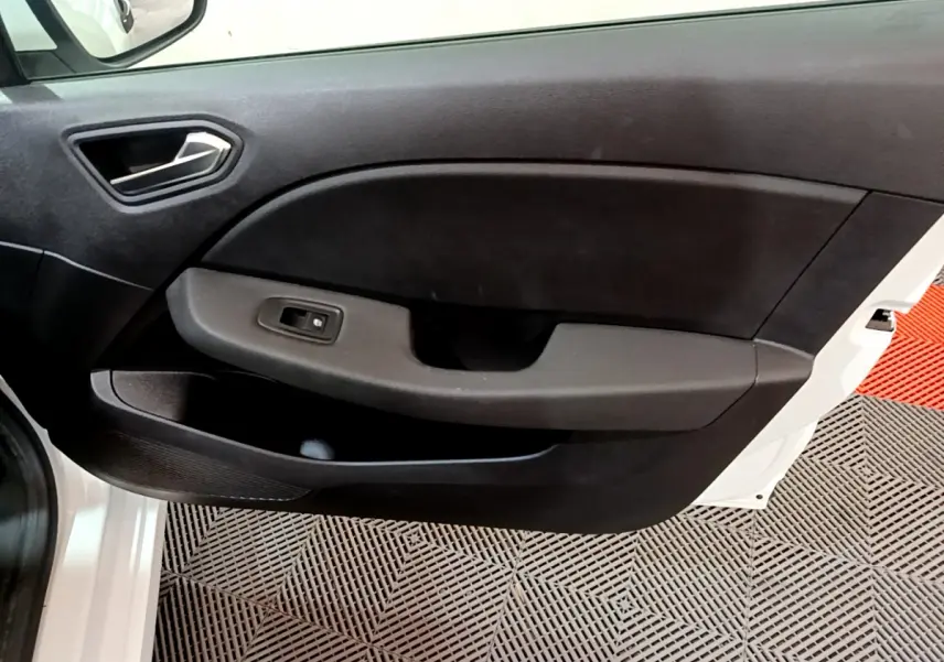 Vue rapprochée de la porte avant gauche blanche de la Renault Clio Business avec panneau intérieur noir et commande de vitre.