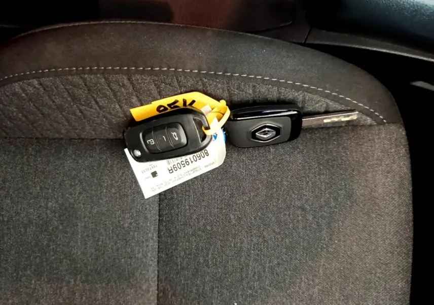 Clé Renault posée sur un siège tissu gris foncé, intérieur d'une Renault Clio Business SCe 65 de 2021.