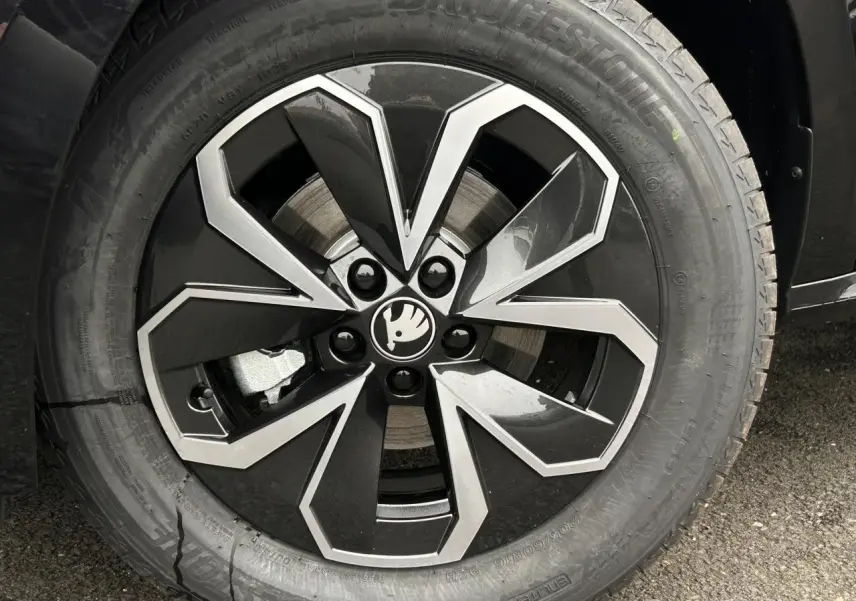 Gros plan sur la jante alliage 16 pouces noire et argent du Skoda Kamiq TSI 116 DSG7 noir Magic.