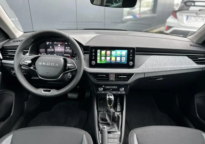 Vue intérieure frontale du Skoda Kamiq 2025, tableau de bord moderne avec écran tactile Apple Car Play et volant multifonctions.