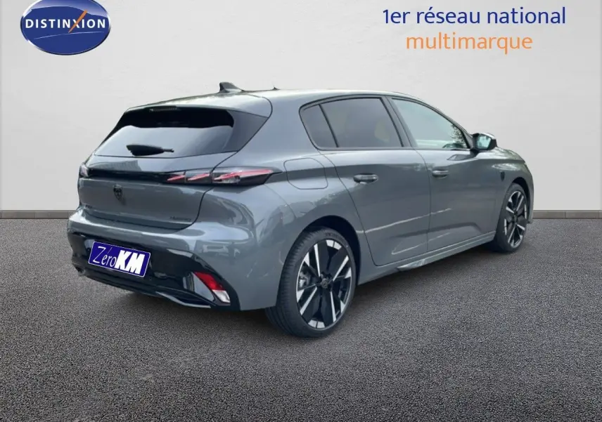 PEUGEOT 308 gris sélénium métal en vue 3/4 arrière droit, soulignant ses feux arrière fins et ses jantes noires bicolores.