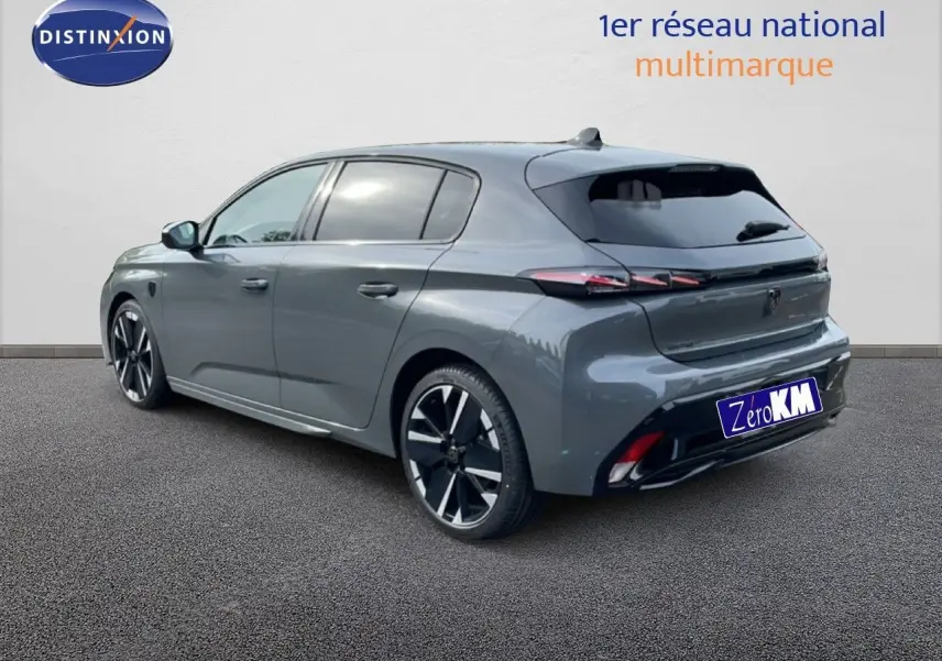 Vue 3/4 arrière droite d'une Peugeot 308 gris selenium métal, avec jantes noires et vitres teintées.