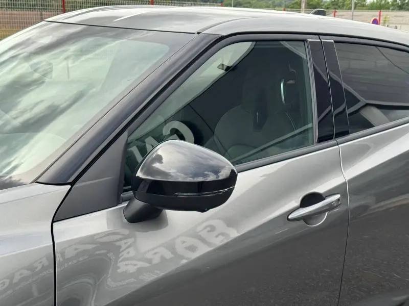 Gros plan sur le rétroviseur noir et la porte côté conducteur du Nissan Juke 2025 noir Kuro métallisé.