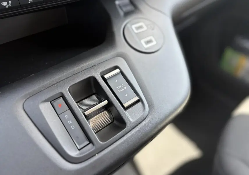 Gros plan sur la console centrale de la Citroën Berlingo ë-136, avec commandes de boîte automatique et mode de conduite.