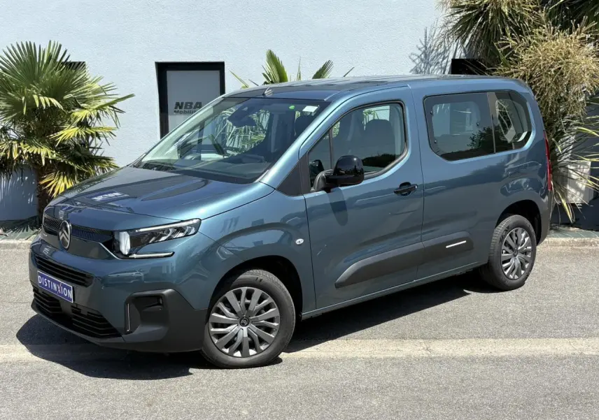 Vue 3/4 avant droite du Citroën Berlingo ë-136 bleu Kiama avec jantes tôles et vitres latérales teintées.