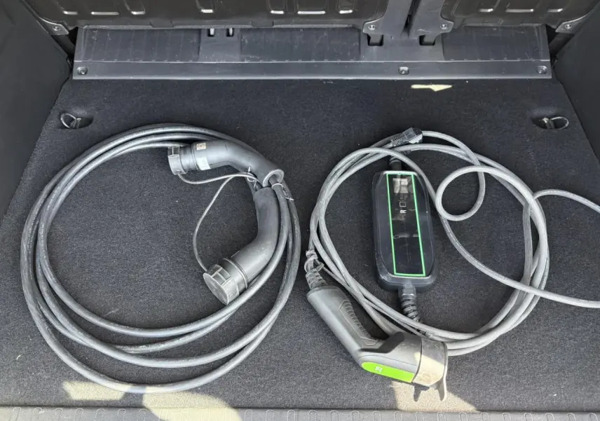 Câbles de recharge électrique rangés dans le coffre d’un Citroën Berlingo ë-136 54kWh bleu Kiama.
