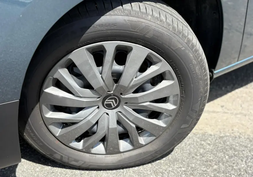 Gros plan sur la jante tôlée 16 pouces avec enjoliveur gris du côté gauche d’un Citroën Berlingo bleu Kiama.
