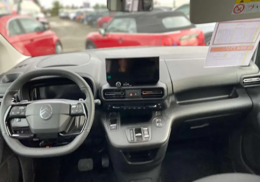 Vue intérieure du tableau de bord du Citroën Berlingo Multispace blanc 2025, avec volant multifonction et écran central.