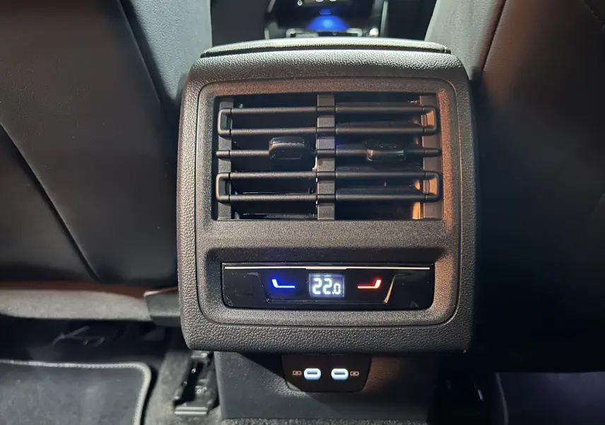 Détail de la ventilation arrière avec réglage de température à 22°C et ports USB dans une Volkswagen Golf VIII eTSI noire.