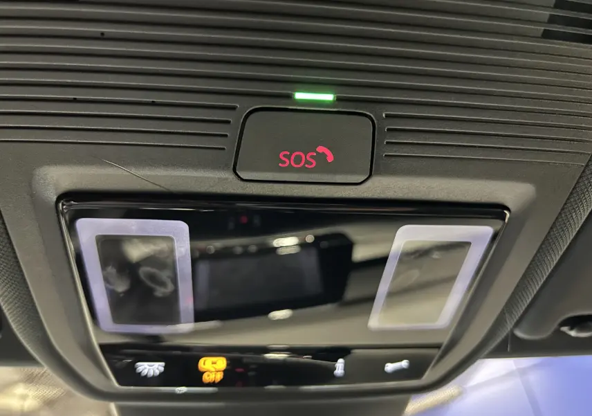 Détail du plafonnier intérieur avec bouton SOS illuminé en rouge dans une Volkswagen Golf VIII noire.