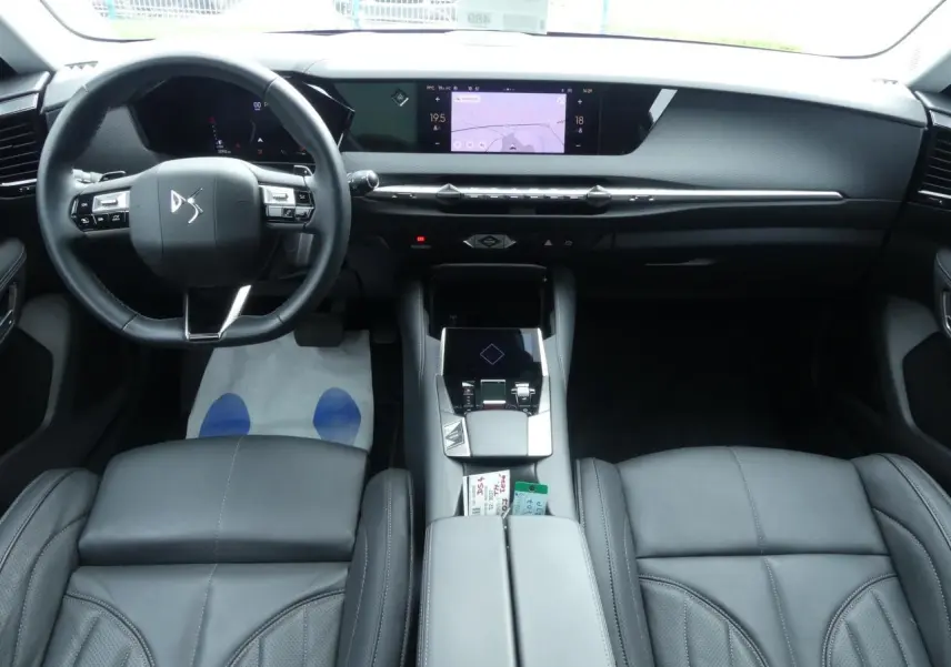 Intérieur noir cuir du DS4 2024 vu de face, avec tableau de bord moderne et écran tactile central lumineux.