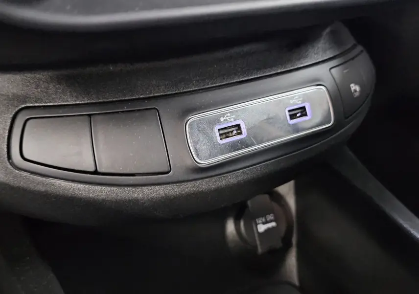 Gros plan sur les ports USB doubles et prise 12V dans l'habitacle noir du FIAT 500X Ph2 hybride 2024.